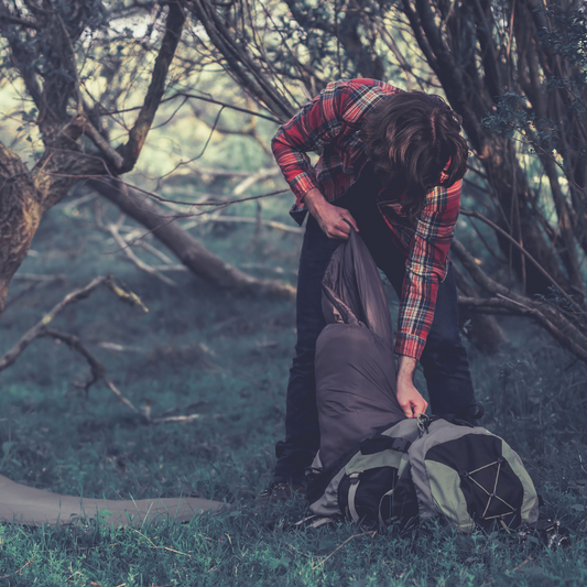 man packing his fishing rucksack backpack